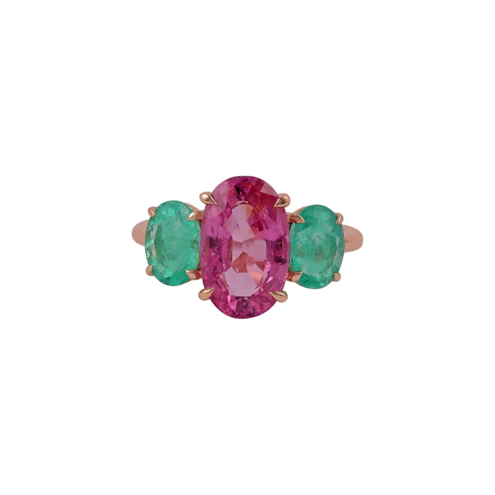 Anillo de oro rosa con un zafiro rosa ovalado flanqueado por dos esmeraldas ovaladas