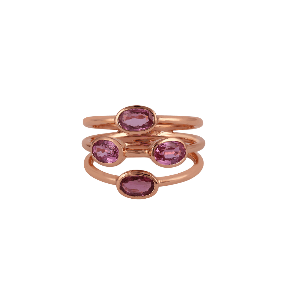 Rose gold ring of three joined bands set with bezelled oval pink sapphires