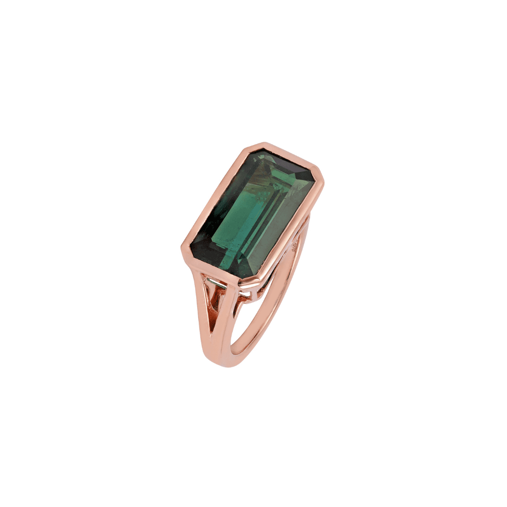 Rose gold ring with a long emerald-cut green stone in a plain bezel along the finger