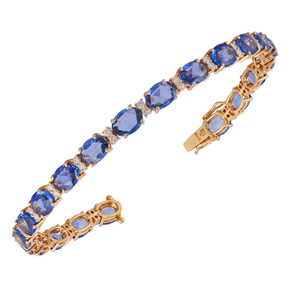 Pulsera de oro amarillo con una línea de zafiros azules ovalados separados por diamantes redondos