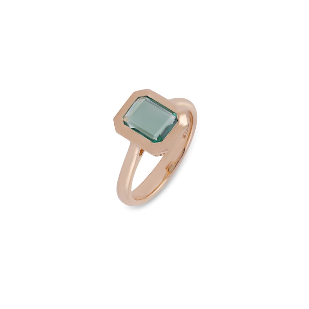 Anillo de oro rosa con una piedra verde pálido de talla esmeralda en un bisel grueso de esquinas cortadas