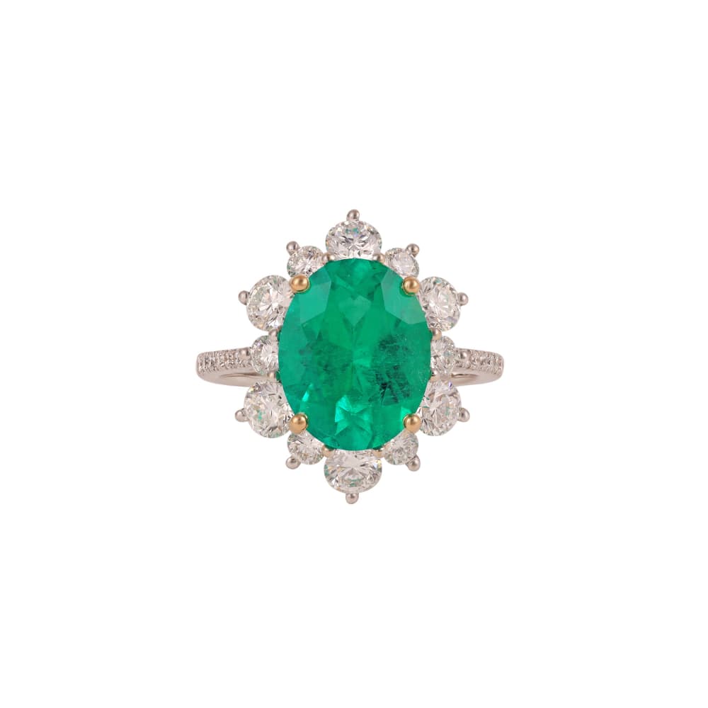 Anillo con una esmeralda ovalada rodeada de diamantes redondos y hombros engastados