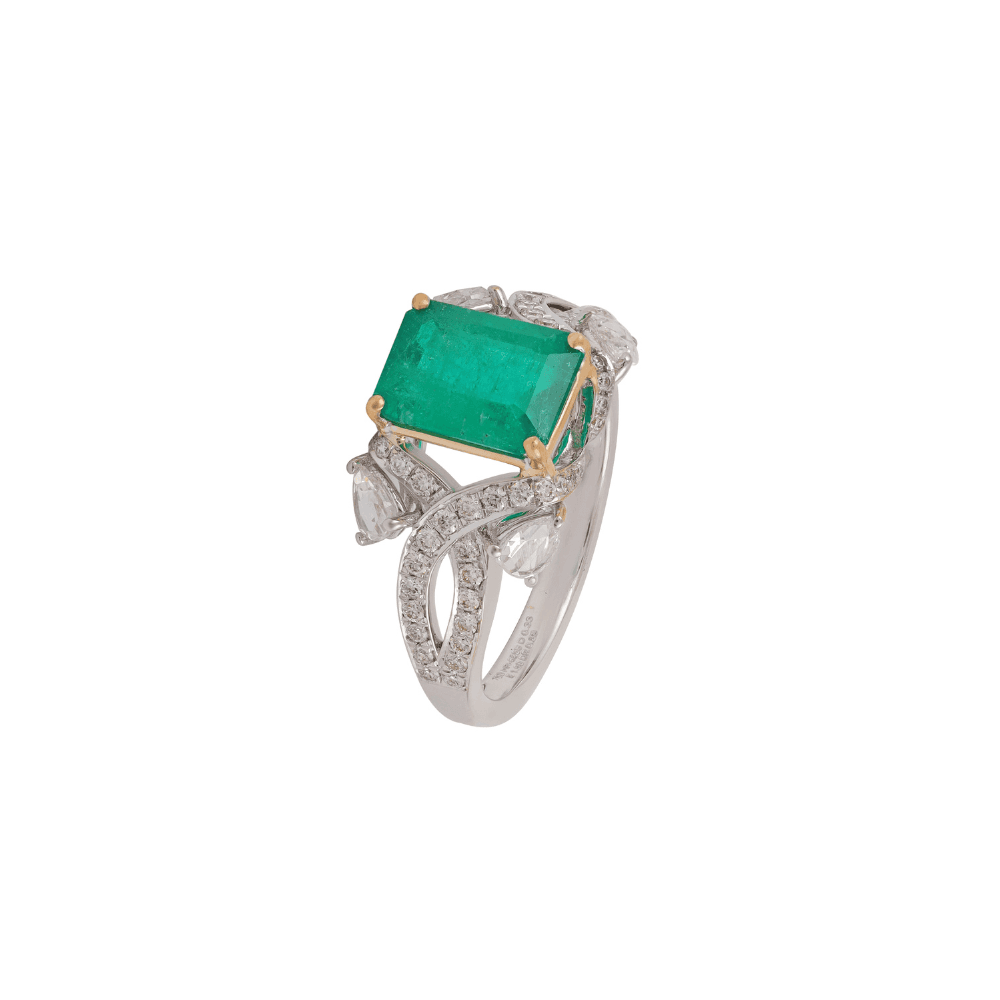 White gold ring with an emerald-cut emerald on yellow gold claws above crossing pavé bands
