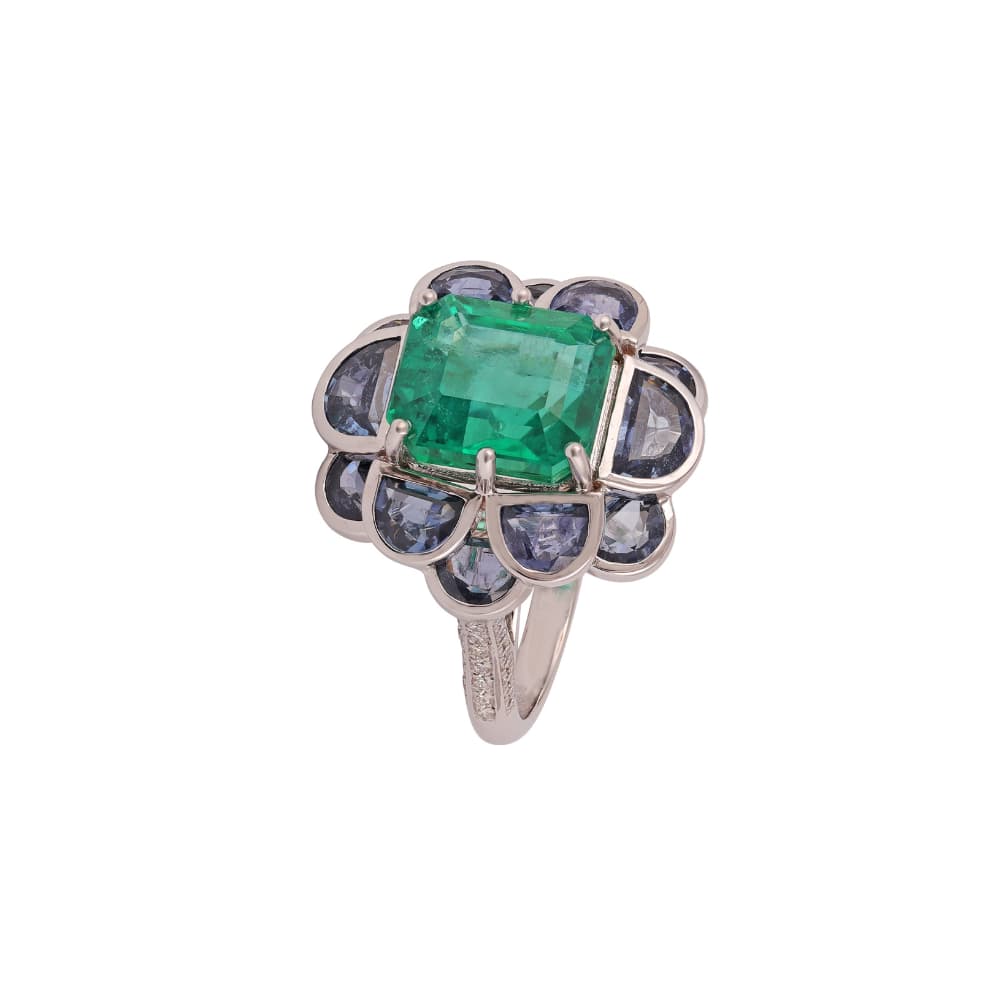 White gold ring with an emerald-cut emerald ringed by grey-blue rose-cut sapphire petals