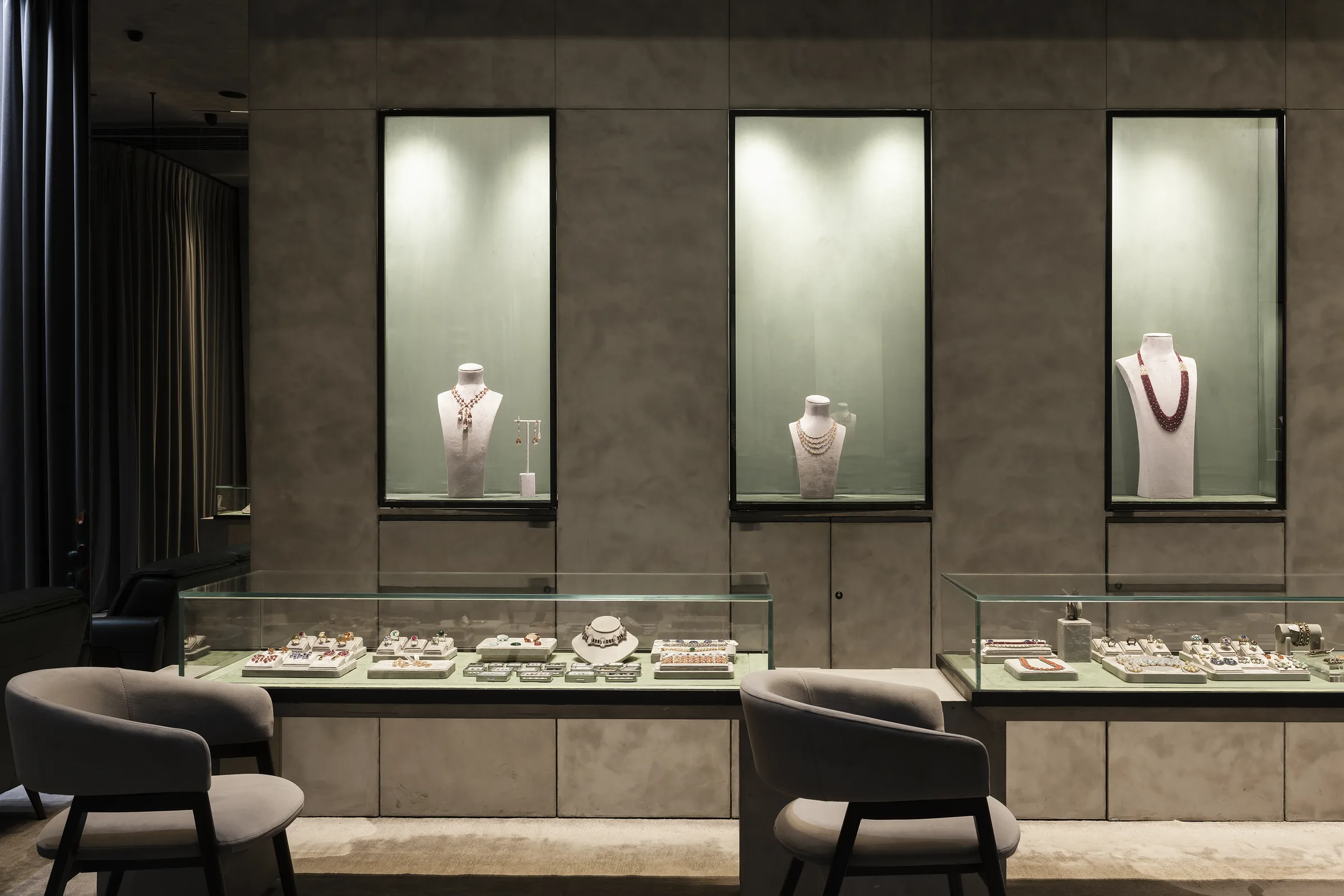 Backlit sage-green vitrines in the Gem Plaza showroom on M.I. Road, Jaipur